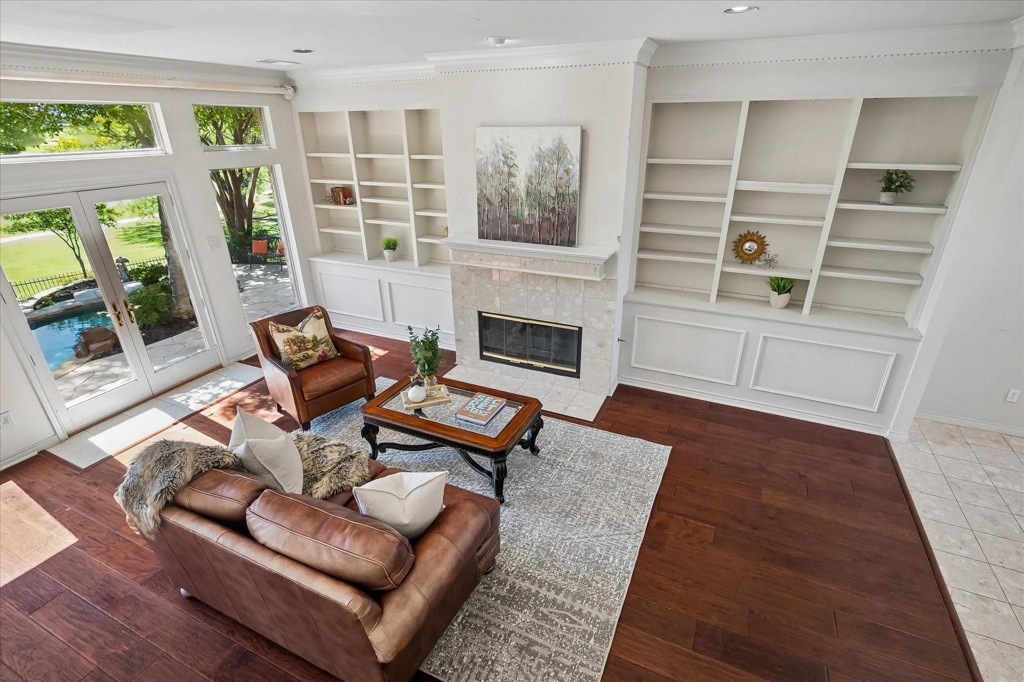 American Hickory hardwood, built-in shelving, stone-surround fireplace, and French doors leading to the outdoor oasis.