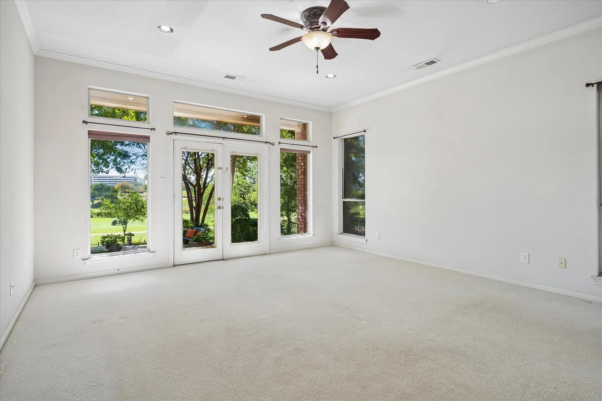 Dual glass French doors, transom windows, recessed lighting, ceiling fan, and crown molding with amazing views of country club and city scape