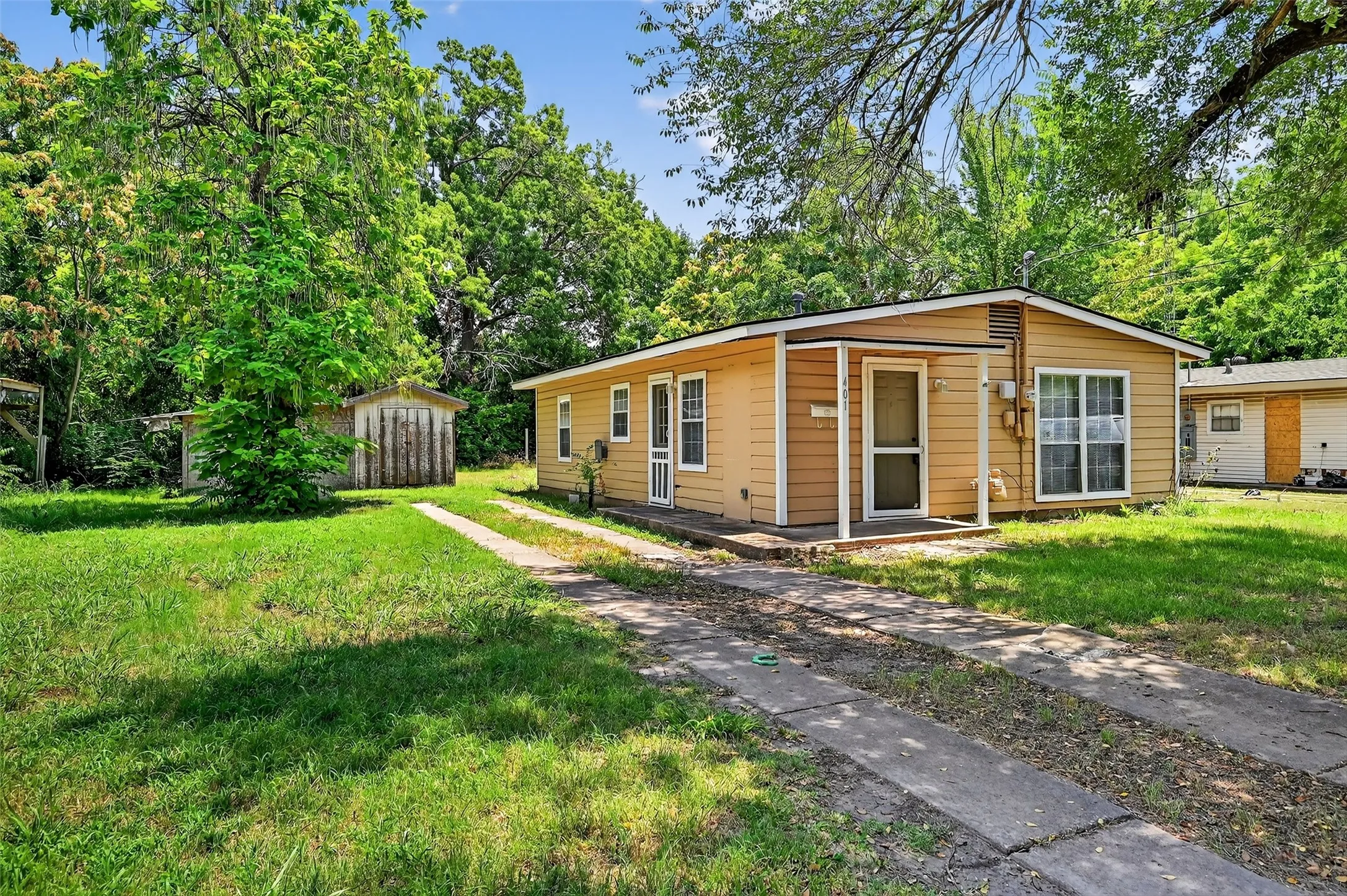View of front of property with a front yard and a shed