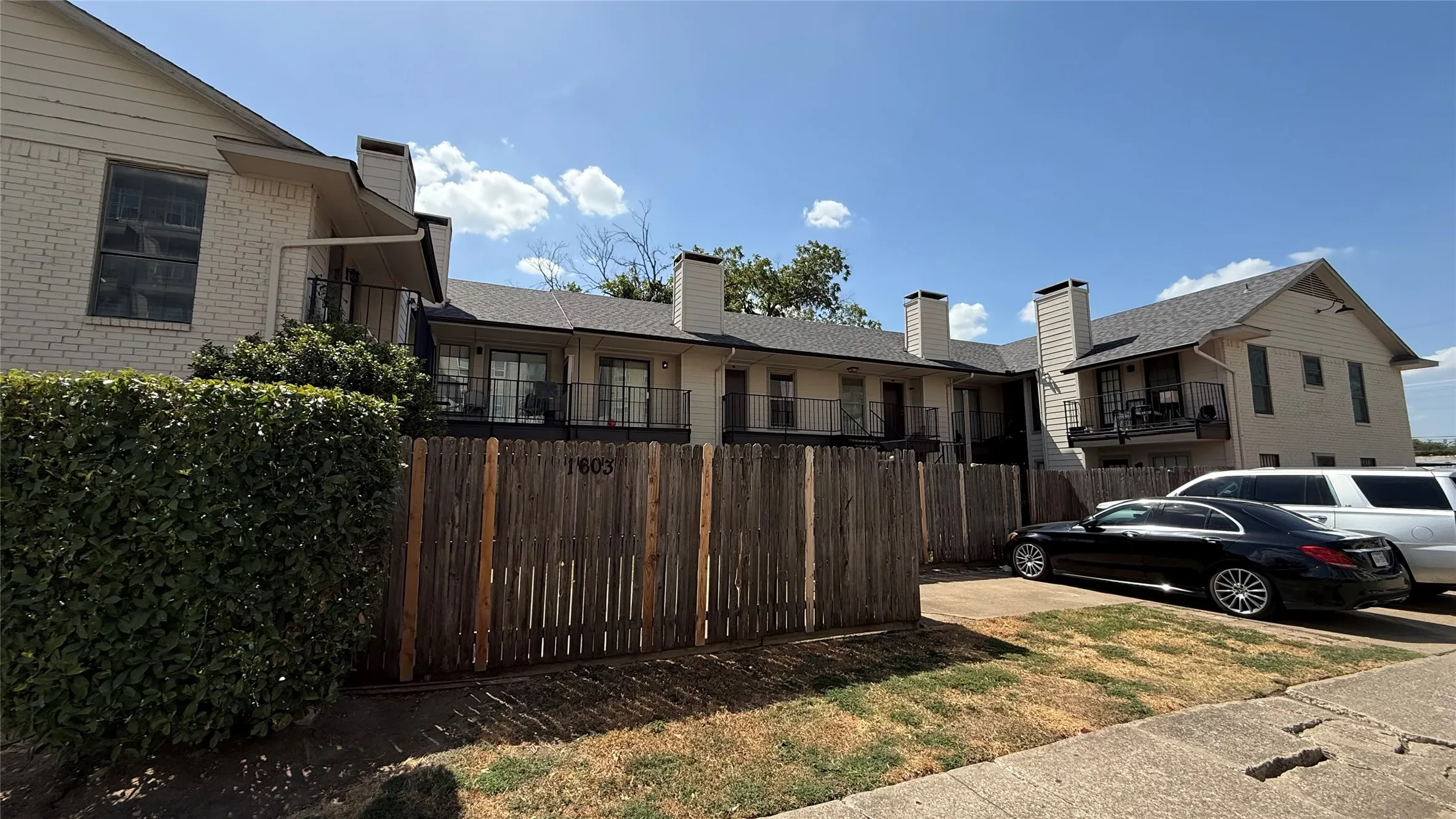 White brick and siding exterior with multiple balconies