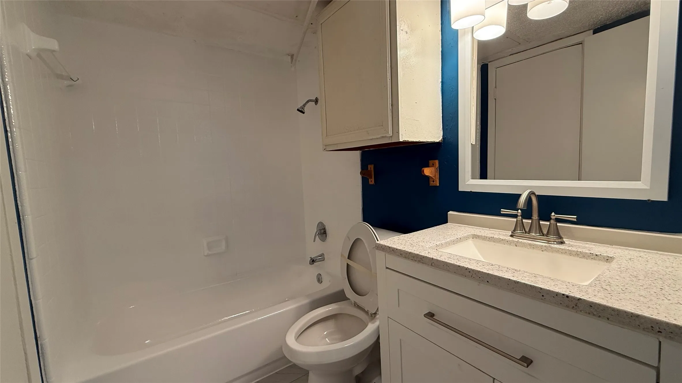 White vanity with an integrated sink and light-toned countertop