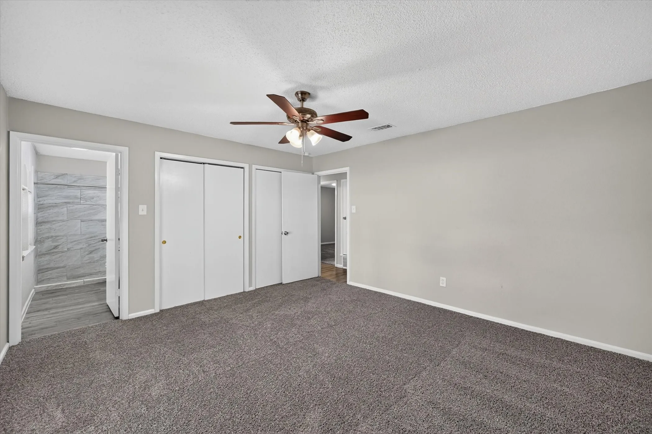 Carpeted room with a ceiling fan, light gray walls, and white trim
