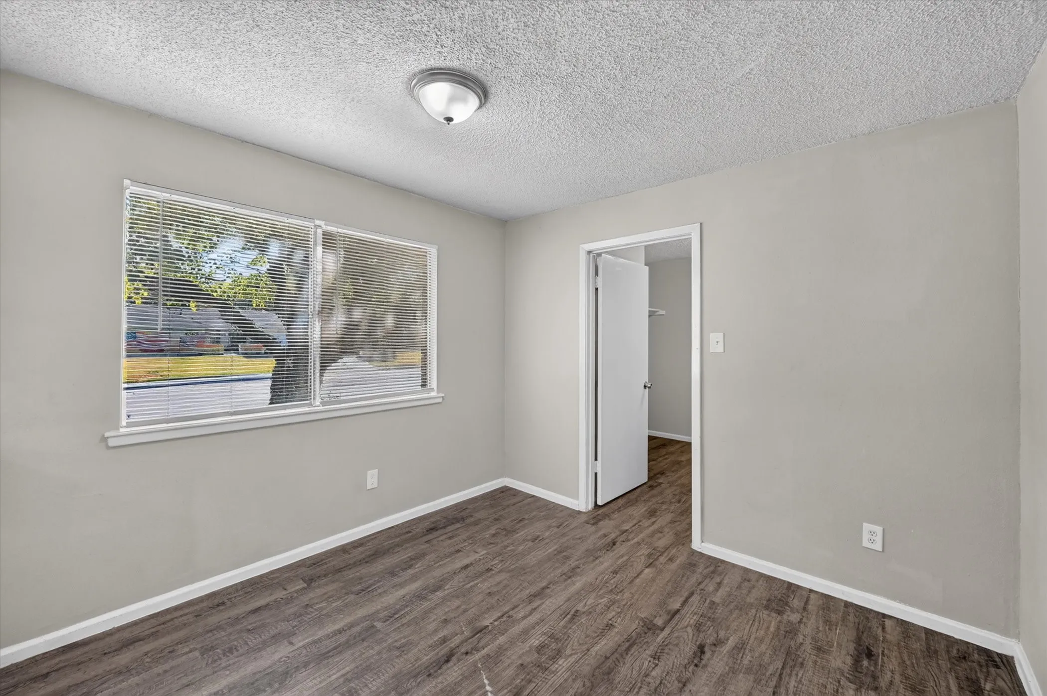 Wood-finish flooring, neutral wall tones, and overhead lighting