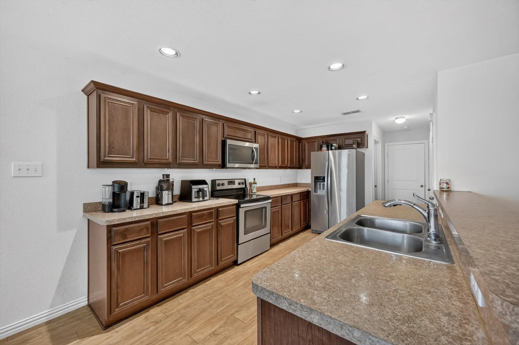 Updated kitchen with wood cabinets and modern appliances in Fort Worth, TX single-family home