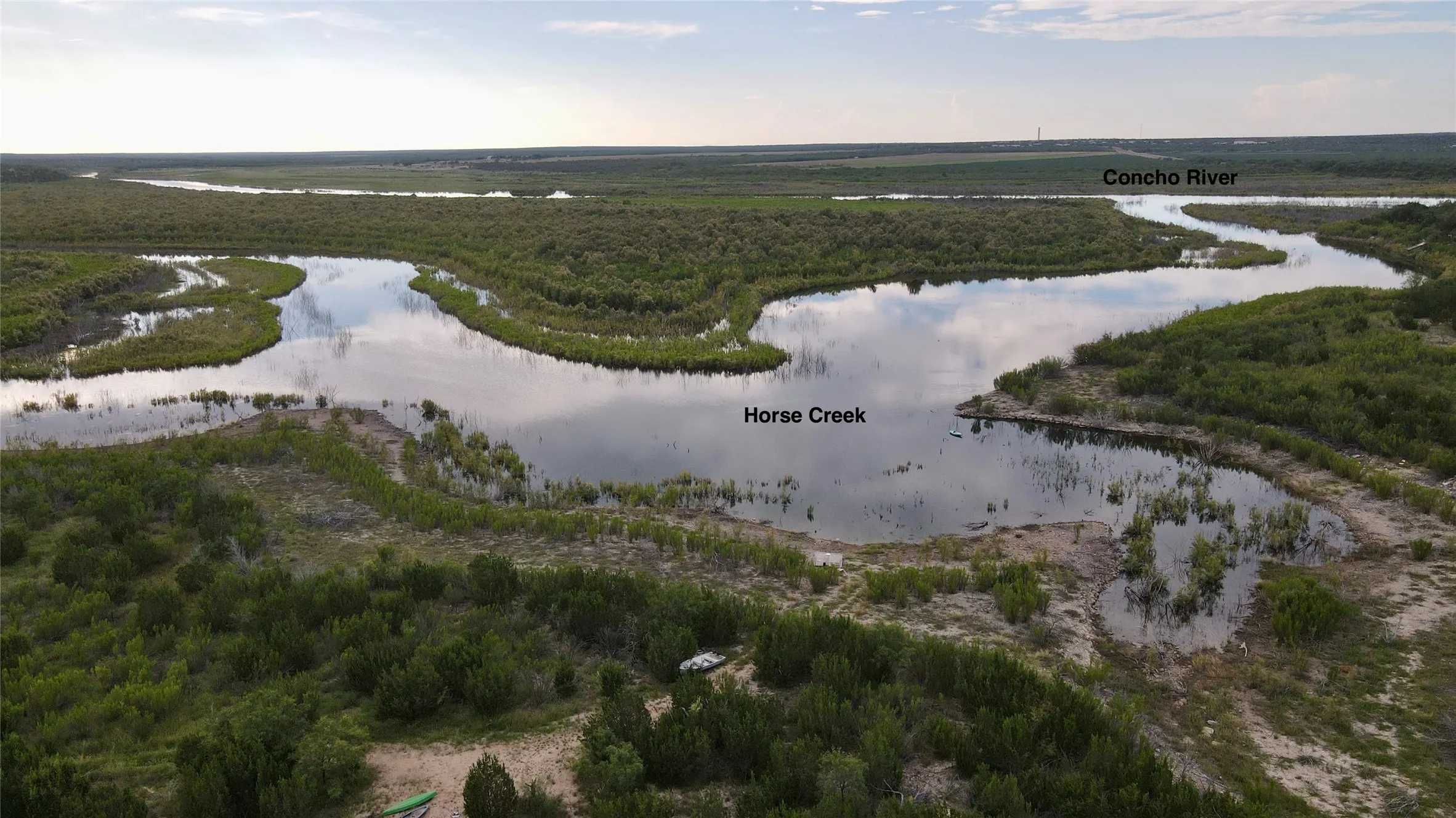 Drone / aerial view of a large body of water and a heavily wooded area