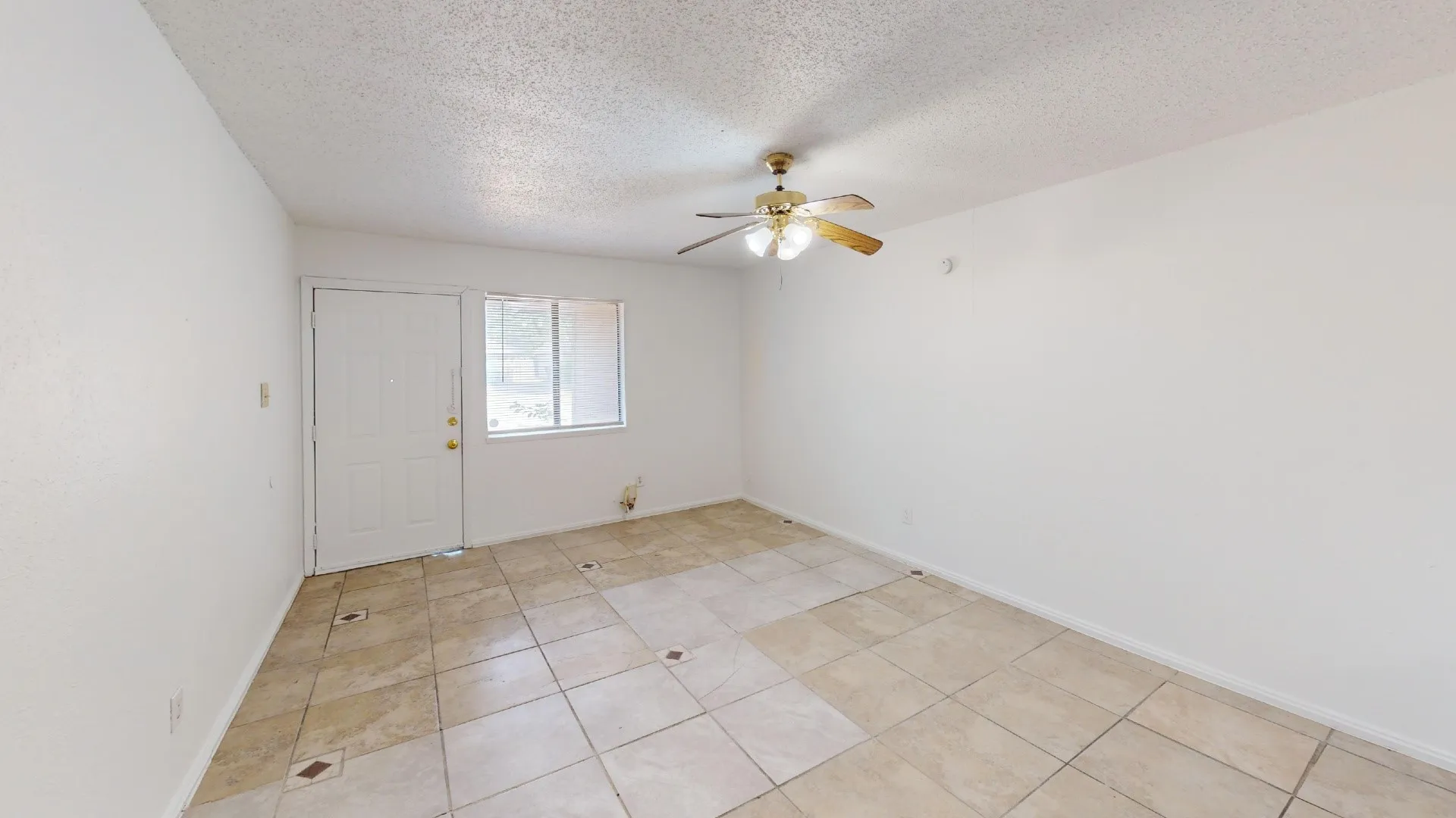 Recessed ceiling with a brass-finish ceiling fan, tiled flooring, and a window with blinds
