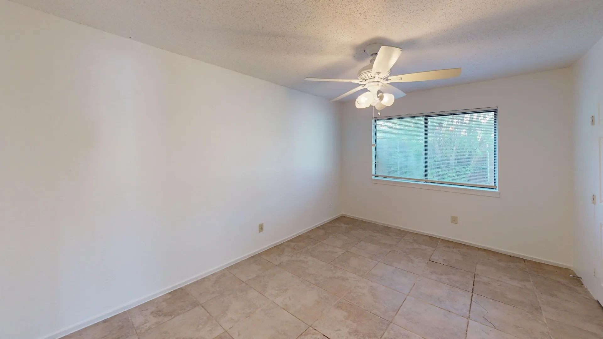 Neutral wall color, ceramic tile flooring, ceiling fan with integrated lighting, and a double-pane window