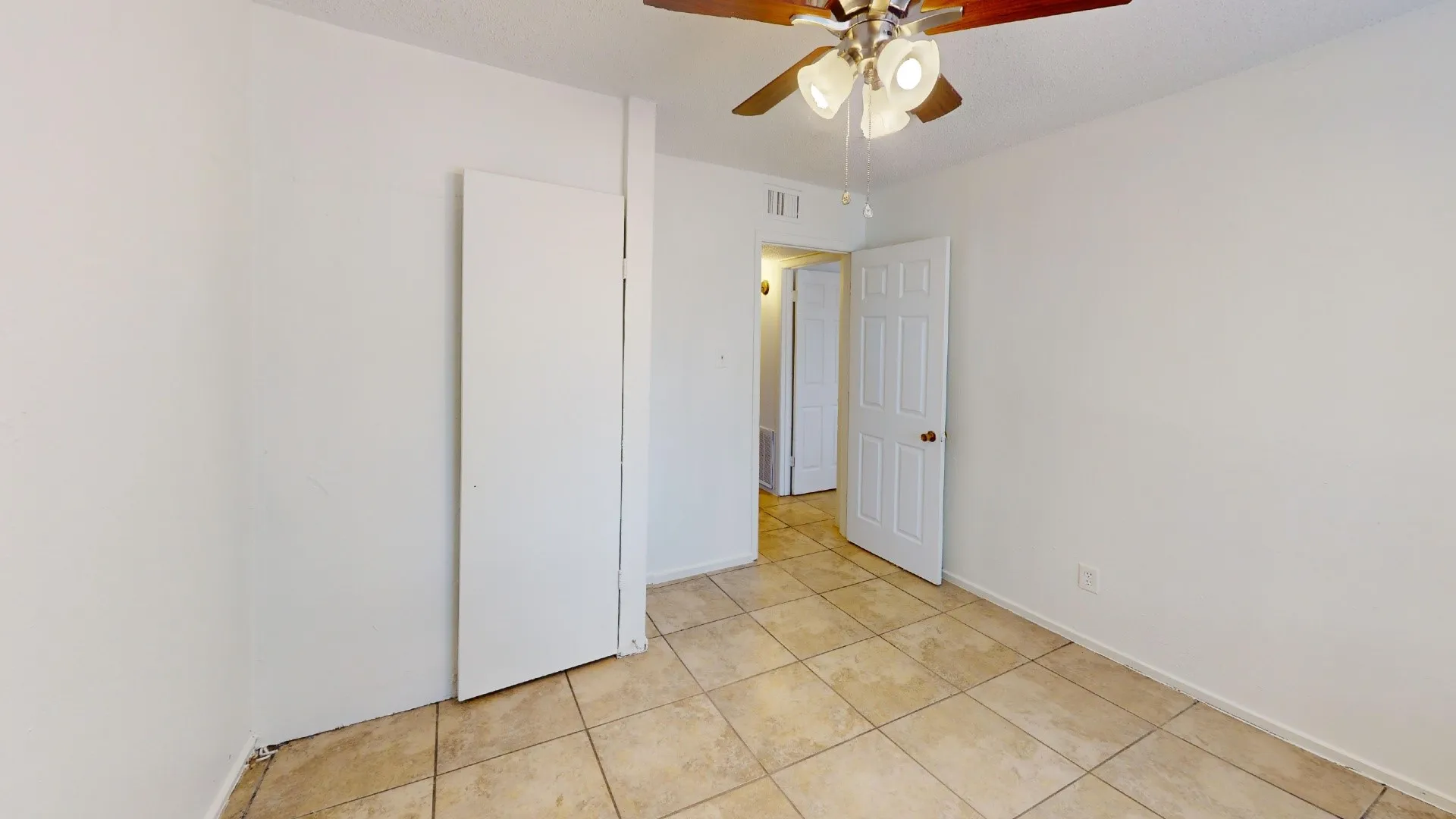 Tiled flooring throughout, featuring a ceiling fan with integrated lighting