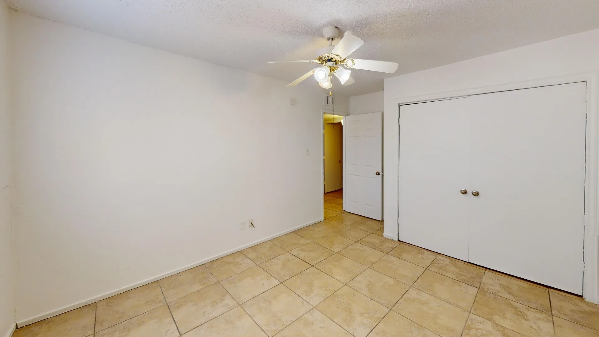 Ceramic tile flooring, bi-fold closet doors, ceiling fan with light fixture, and a paneled interior door