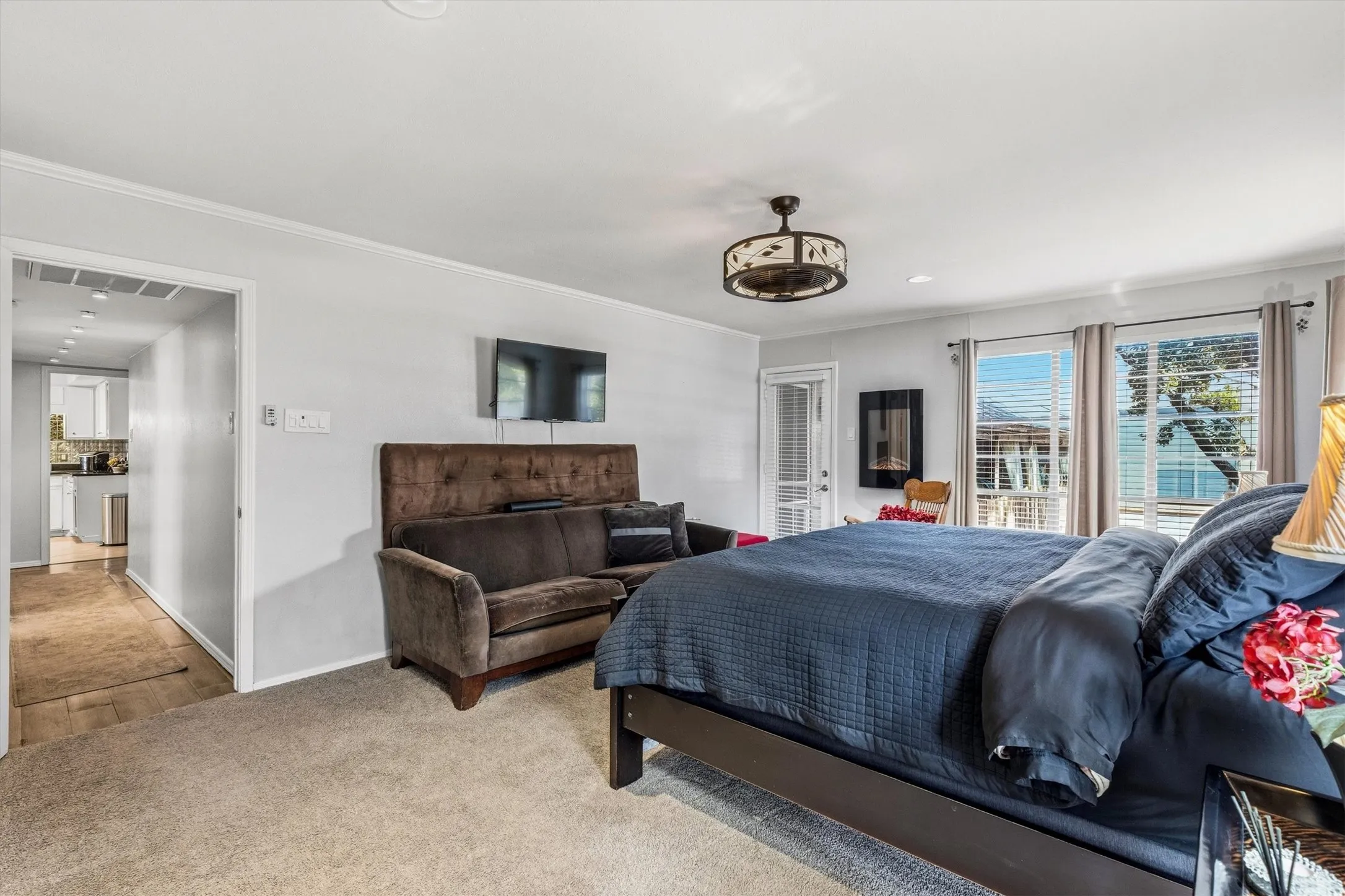 Recessed lighting, ceiling fan light fixture, transom window over door, large windows with blinds, and carpeted flooring