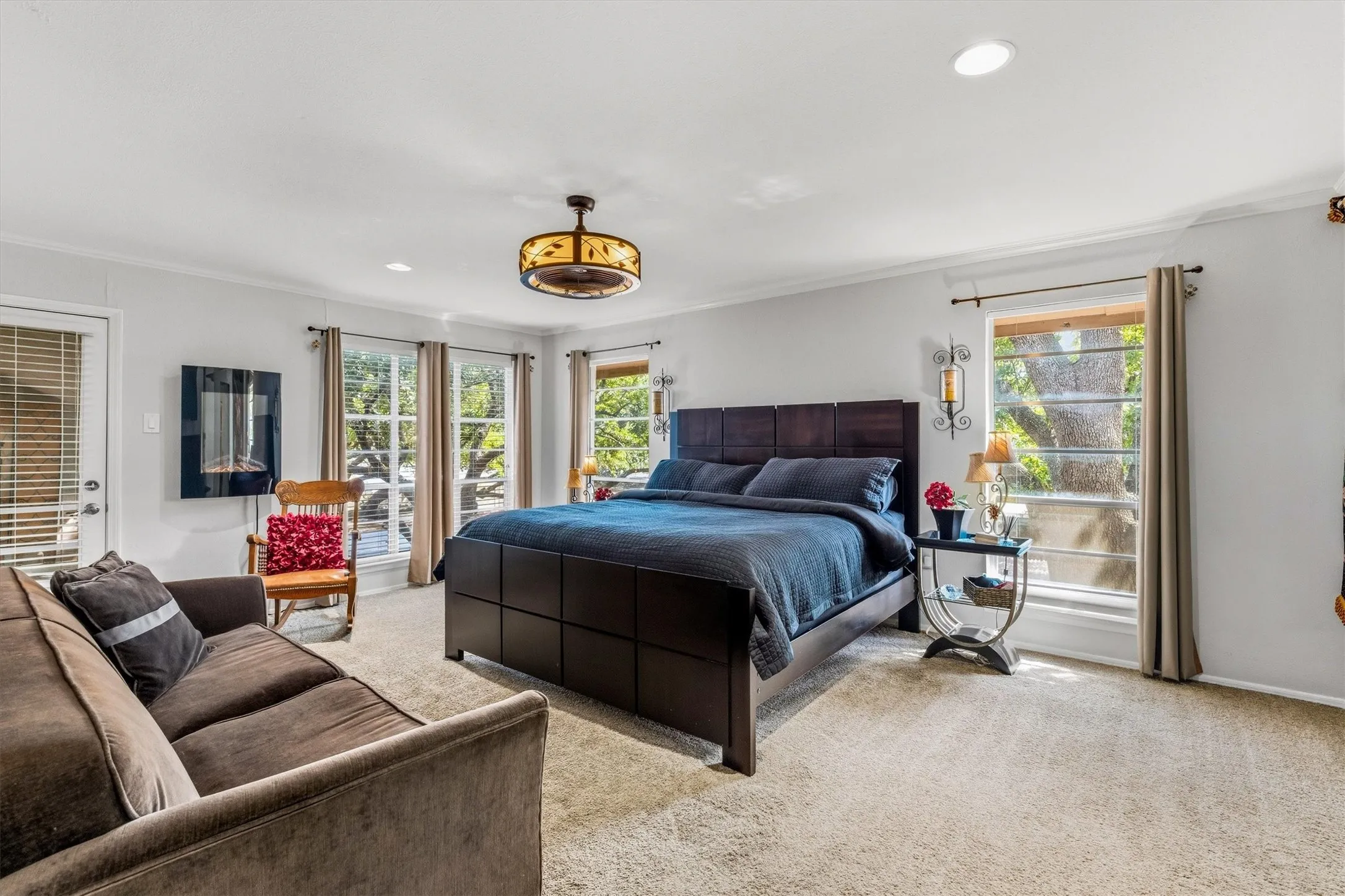 Carpeted flooring, recessed lighting, and multiple windows providing natural illumination