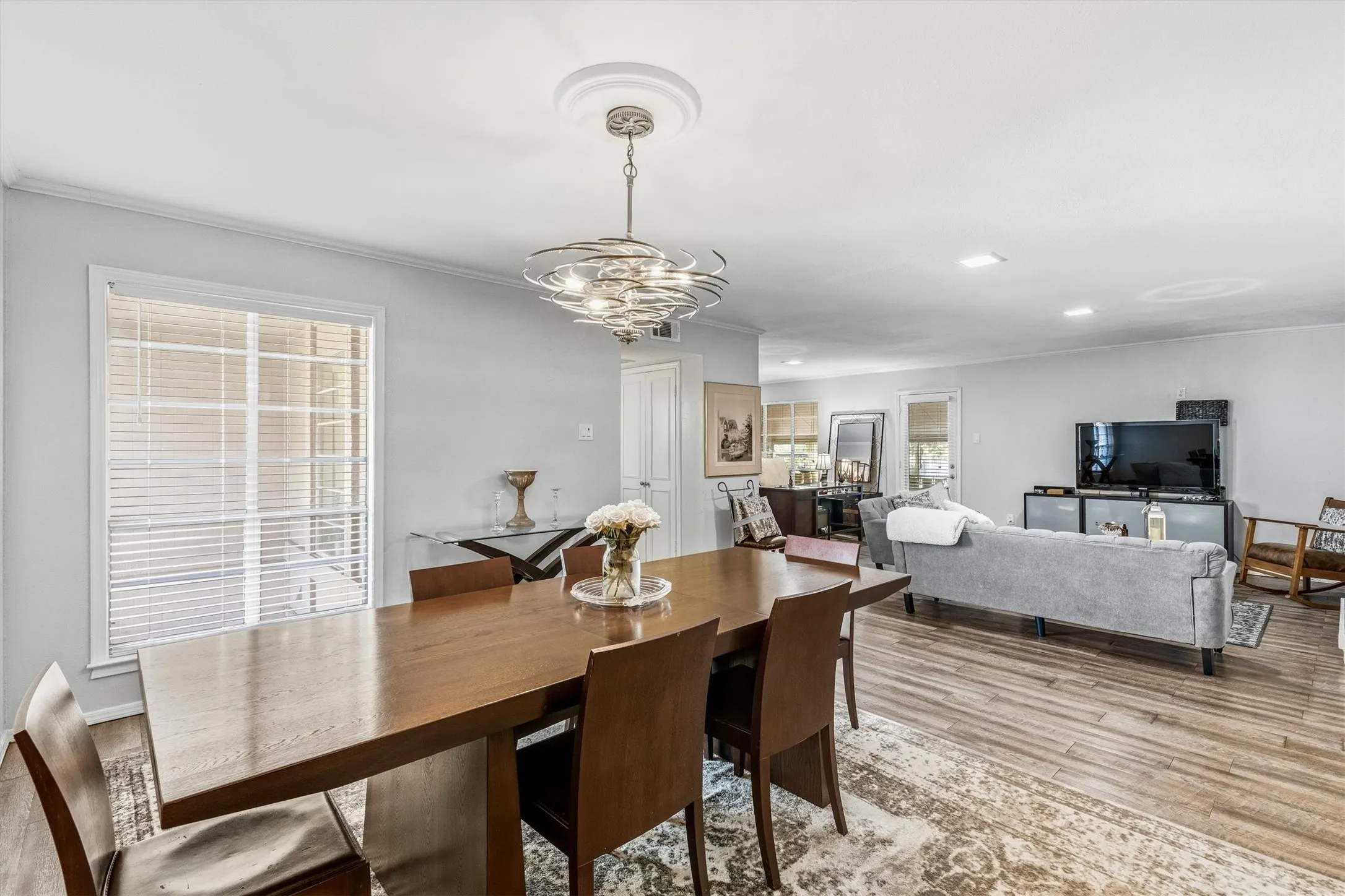 Wood-finish flooring, recessed lighting, and a modern chandelier