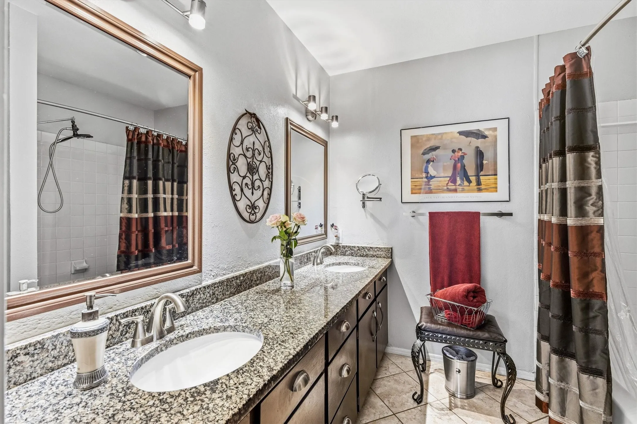 Dual vanity with granite countertop, integrated sinks, dark wood-finish cabinetry, and brushed nickel fixtures