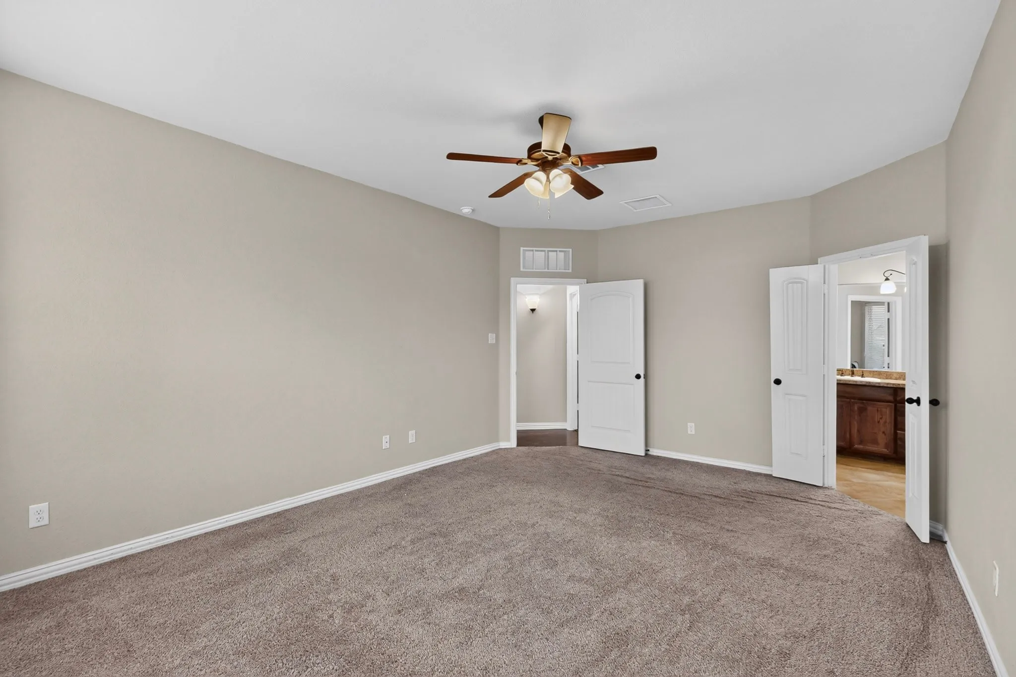 Neutral tone wall finishes, ceiling fan with integrated lighting, plush carpeting, and white paneled doors