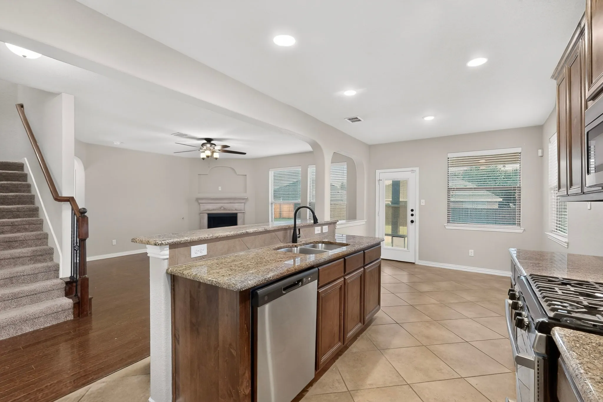 Kitchen island with integrated sink, stainless steel dishwasher, and granite countertops
