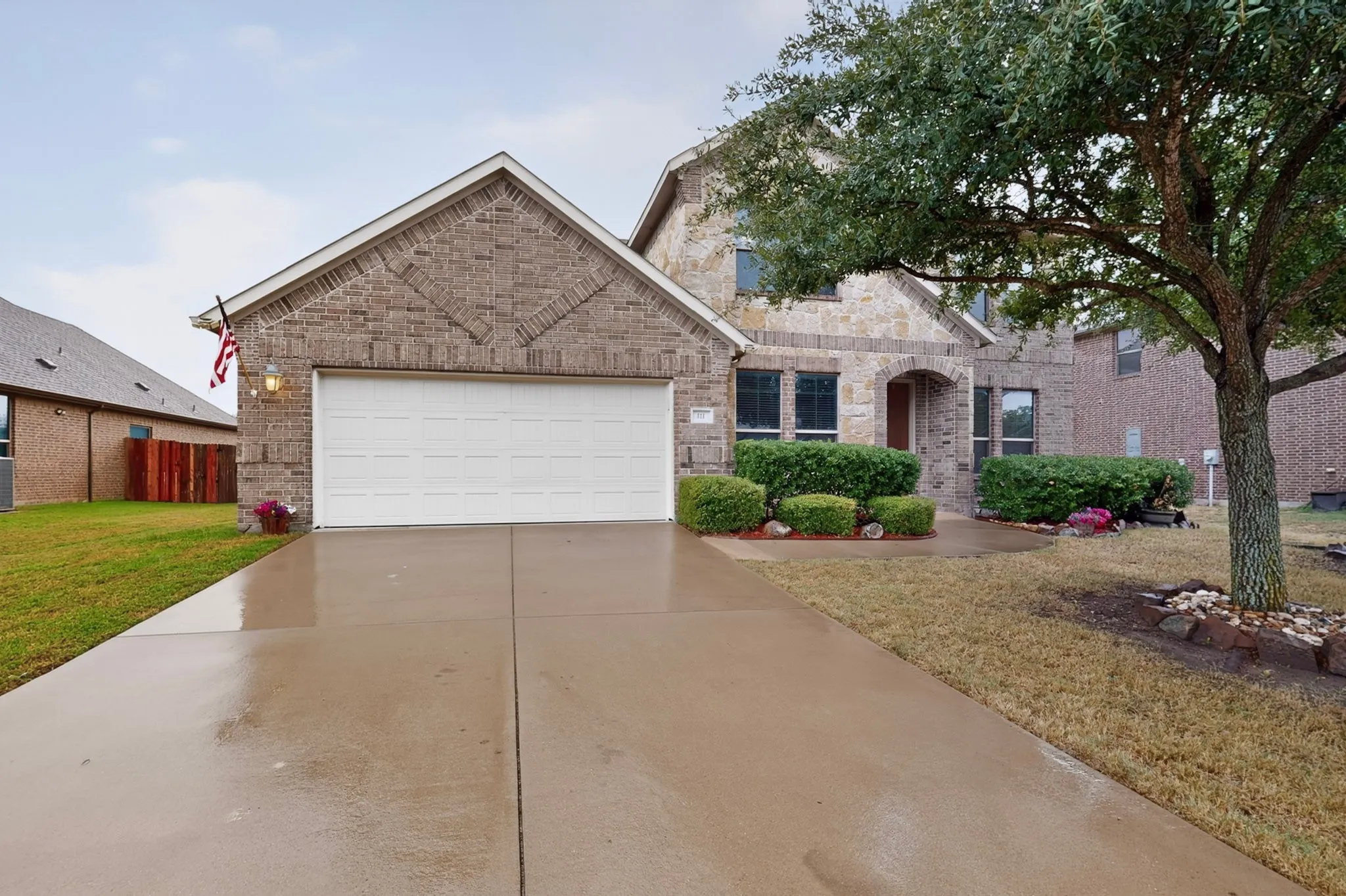 Brick and stone exterior with an attached two-car garage