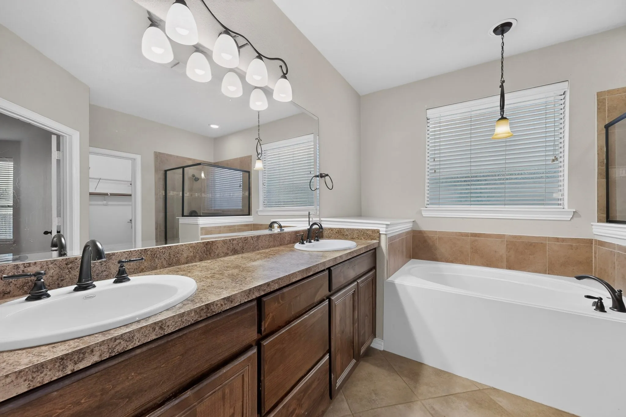Dual vanity with integrated sinks, dark wood-finish cabinetry, and a large mirror
