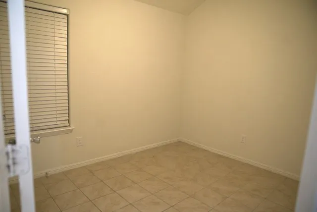 Ceramic tile flooring, window with horizontal blinds, and neutral wall paint