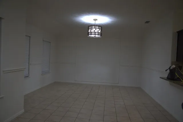 Recessed ceiling light, tile flooring, window with blinds, decorative wall molding, and a built-in countertop