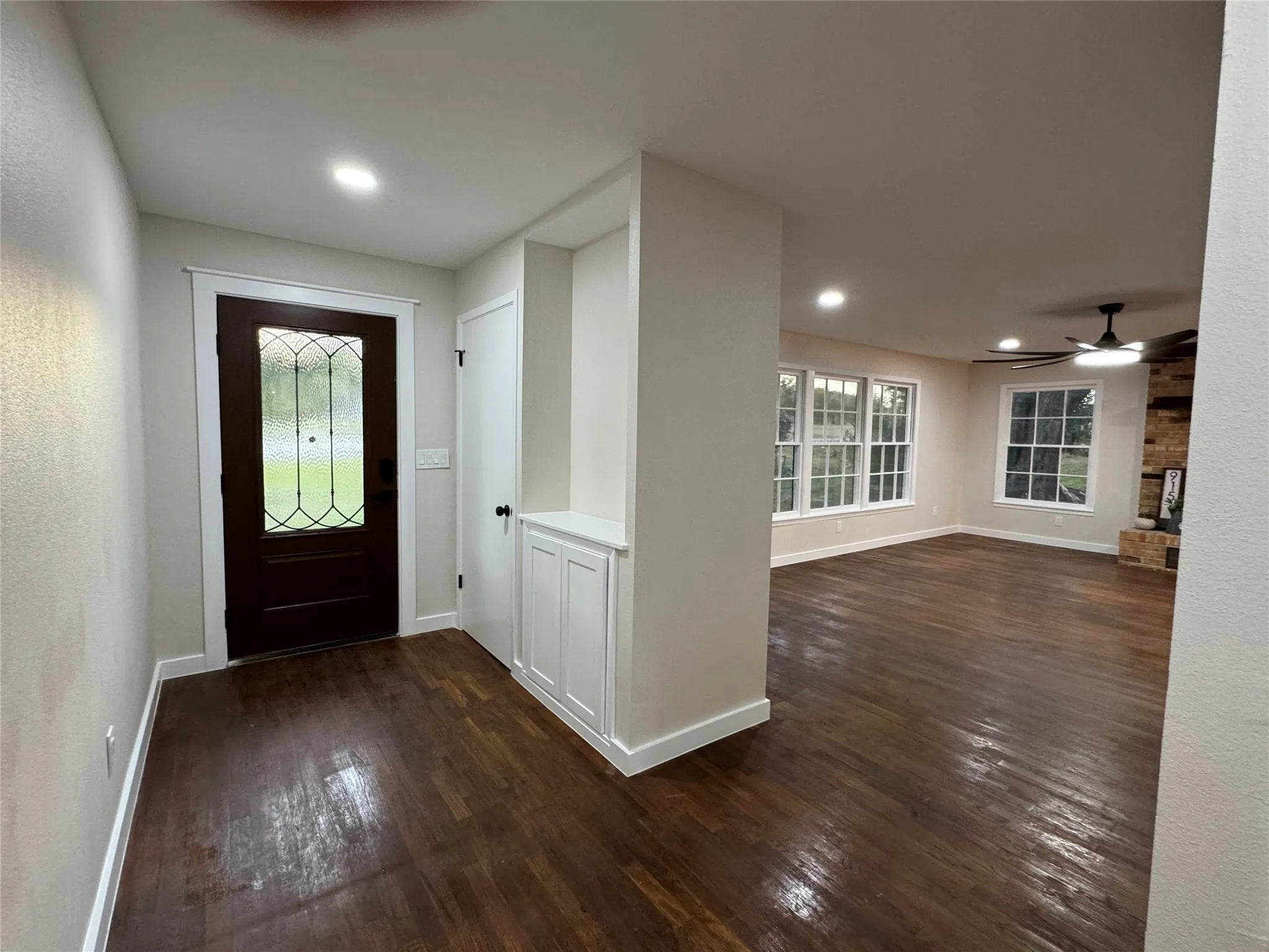 Entrance foyer with dark hardwood / wood-style flooring and ceiling fan
