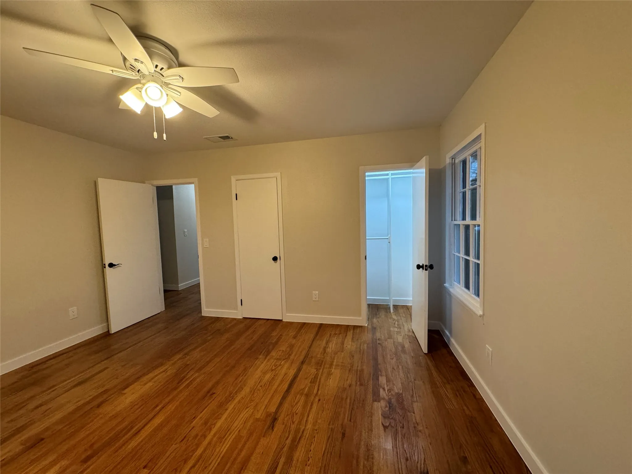 Unfurnished bedroom with a closet, ceiling fan, and dark hardwood / wood-style floors