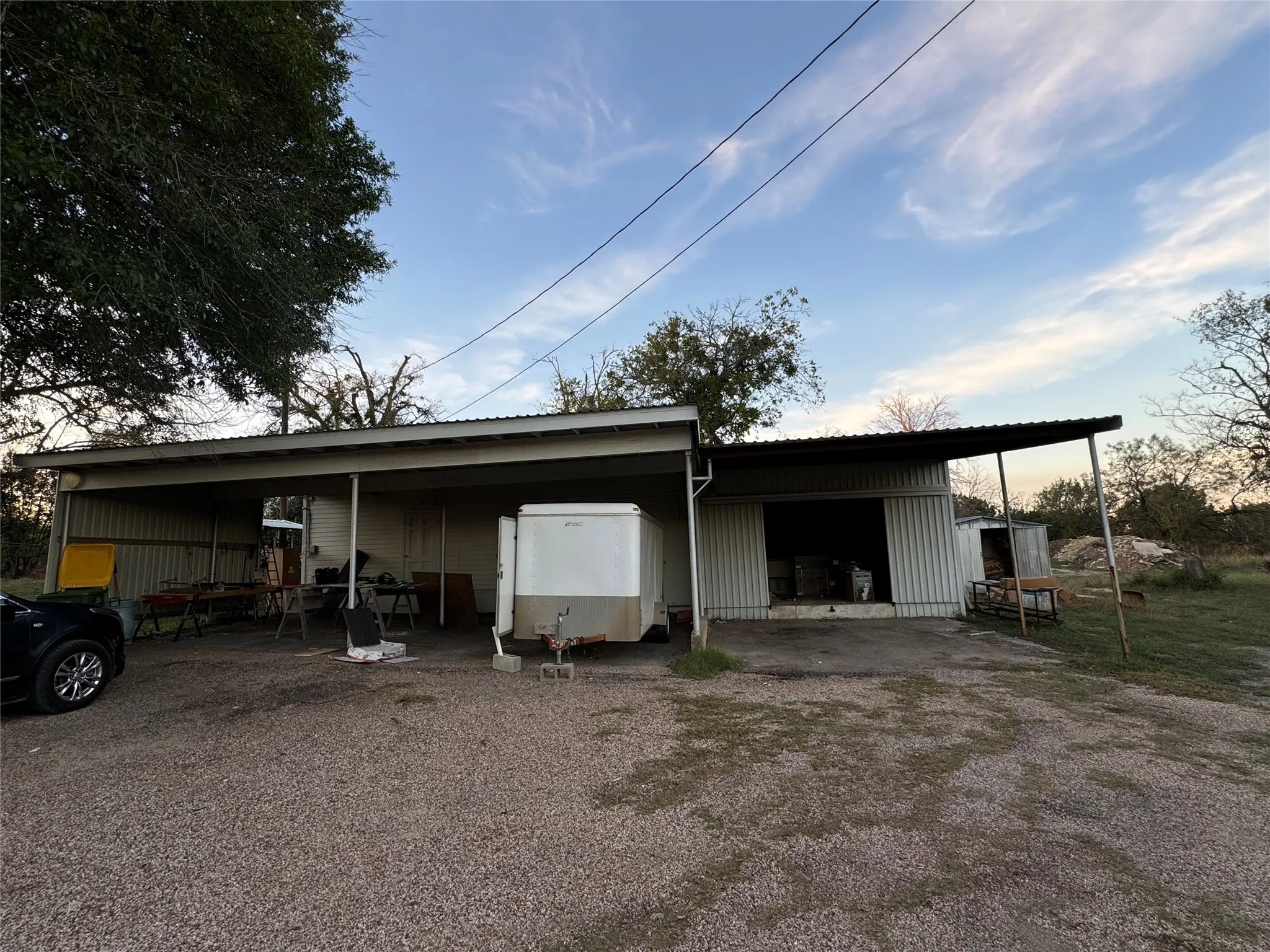 Outdoor structure at dusk with a carport