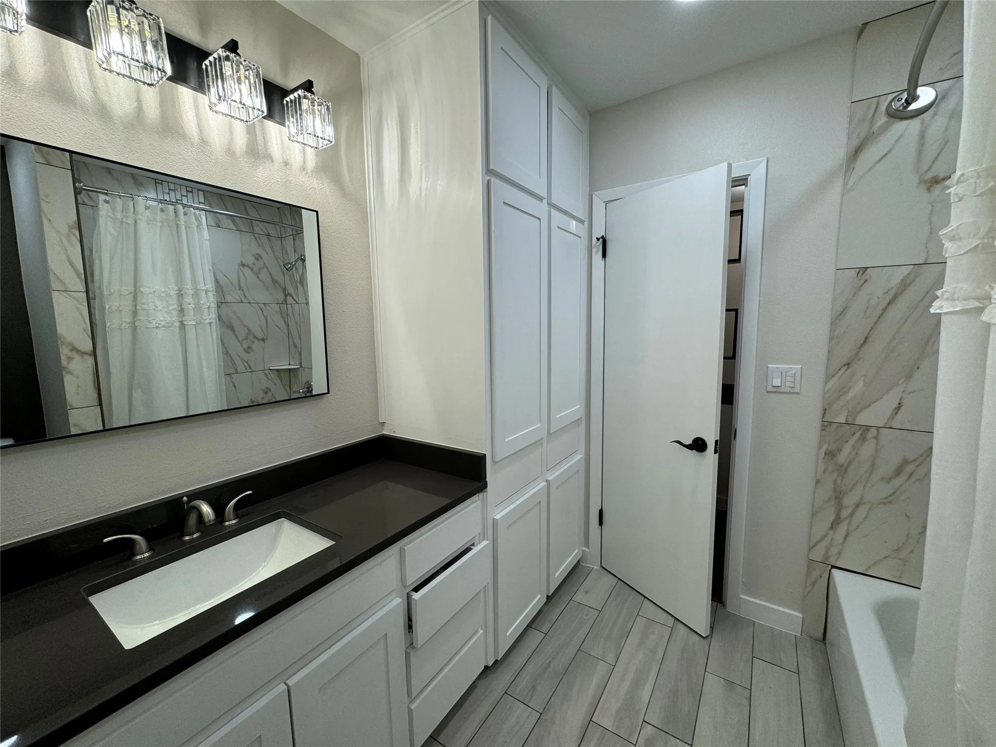 Bathroom with vanity and tiled shower / bath