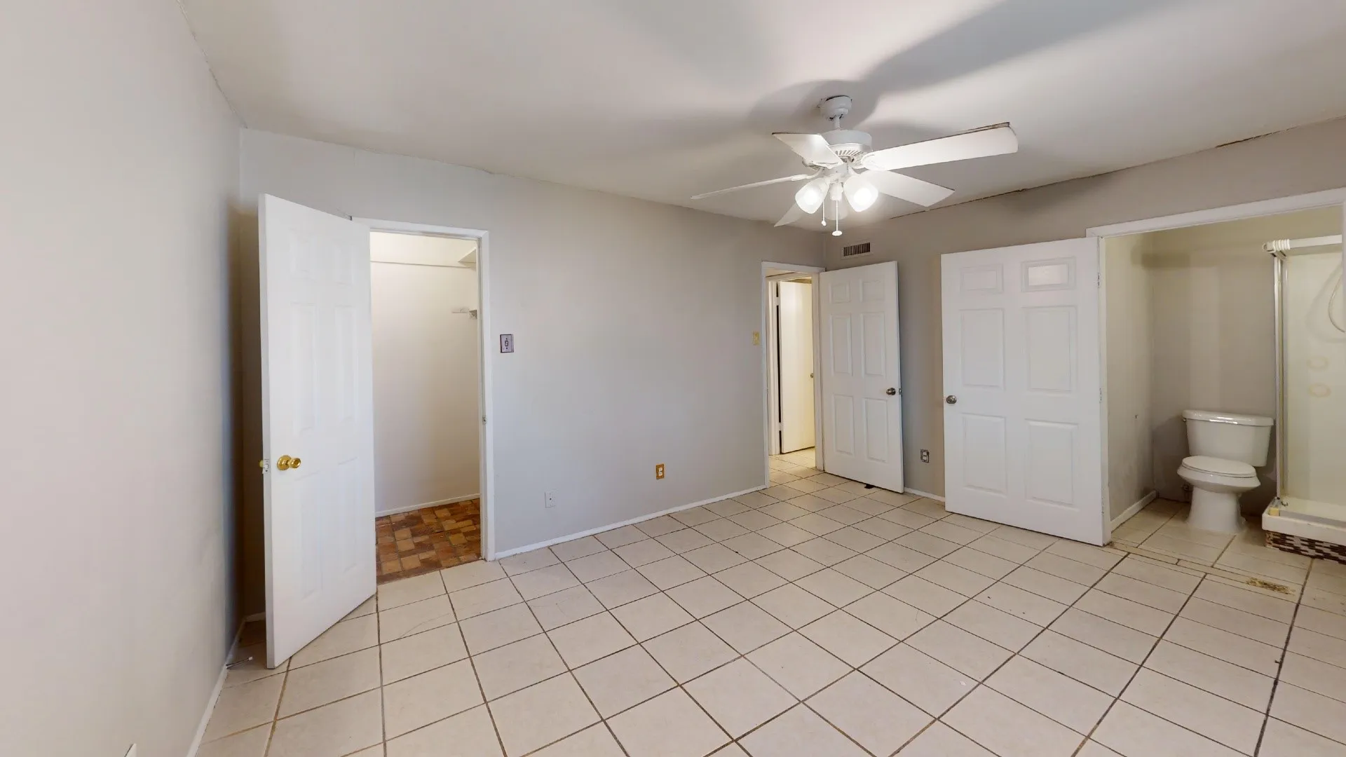 Tiled flooring, ceiling fan with integrated lighting, and multiple access doors