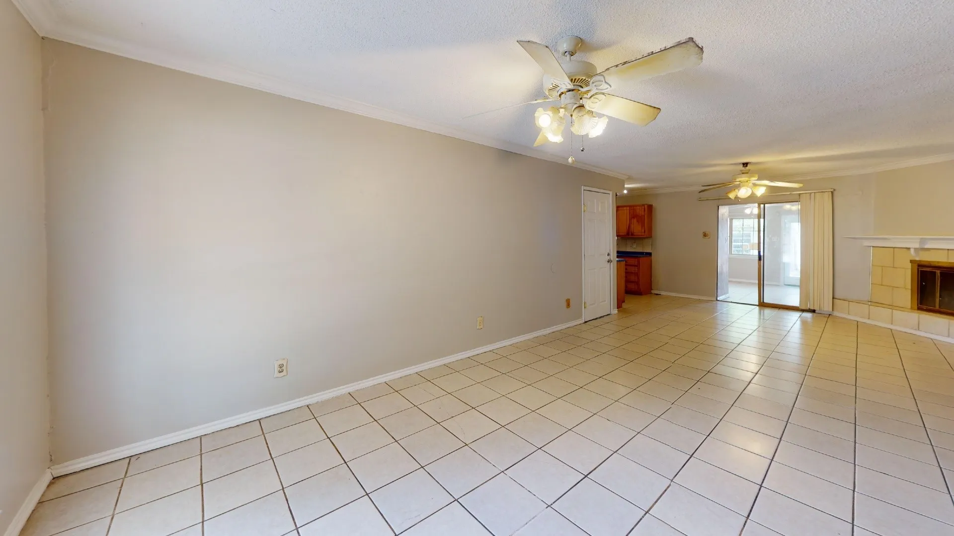 Spacious interior featuring neutral tone walls, tile flooring, and multiple ceiling fans