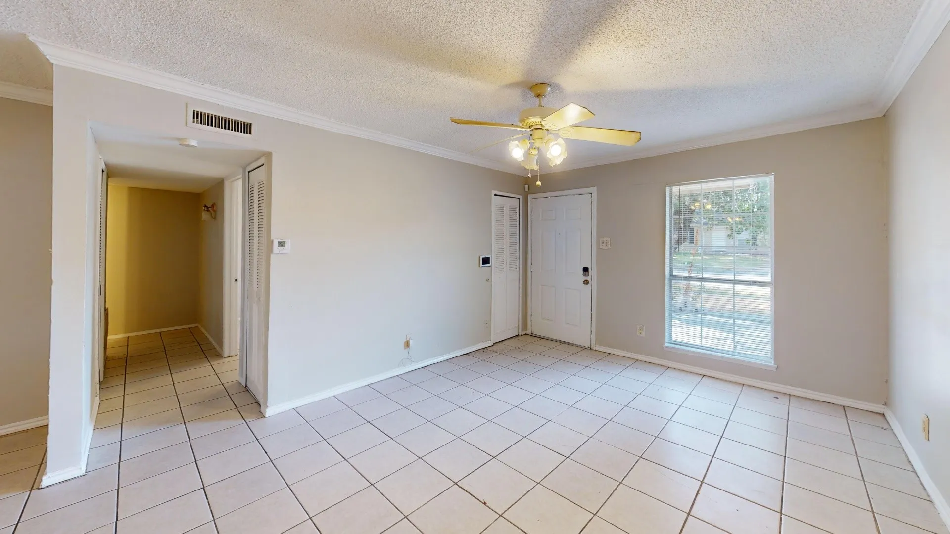 Tile flooring throughout, with crown molding and a ceiling fan