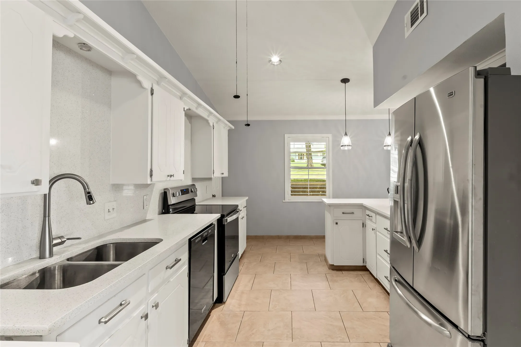 Kitchen featuring white cabinetry, light-toned countertops, stainless steel appliances, and tile flooring