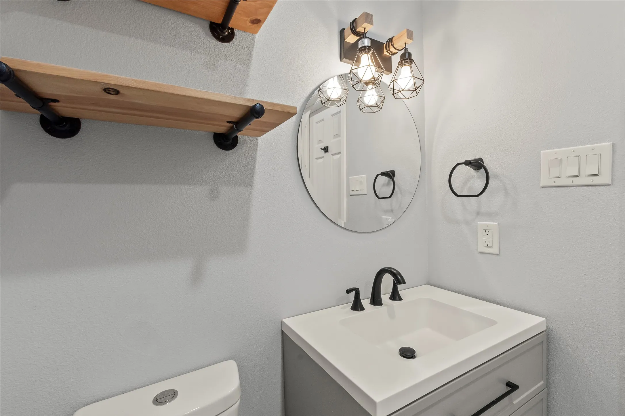 Vanity with integrated sink, matte black faucet, and cabinet storage