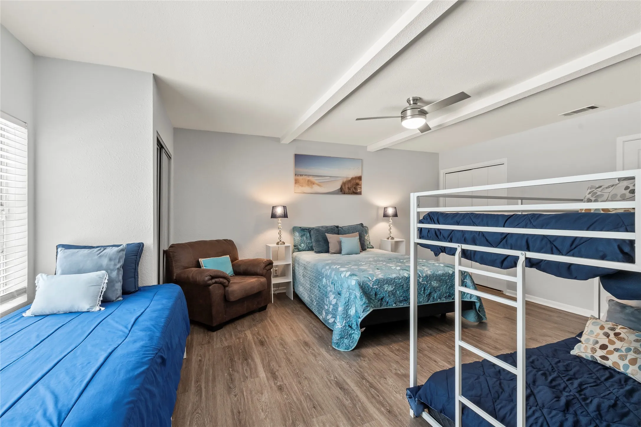 Wood-finish flooring, ceiling fan, white window blinds, and built-in closet doors