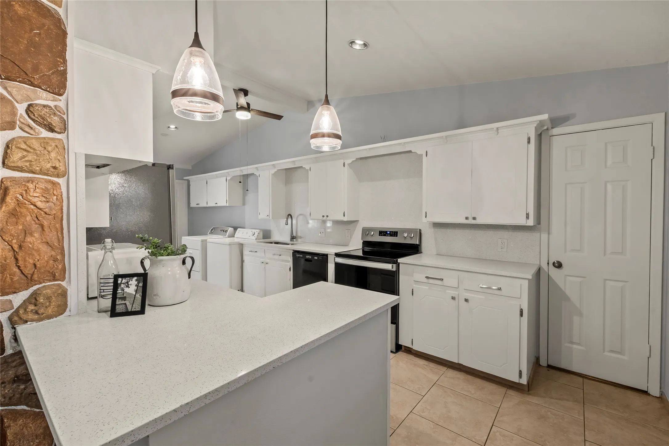 White cabinetry, light-toned countertops, and tile flooring
