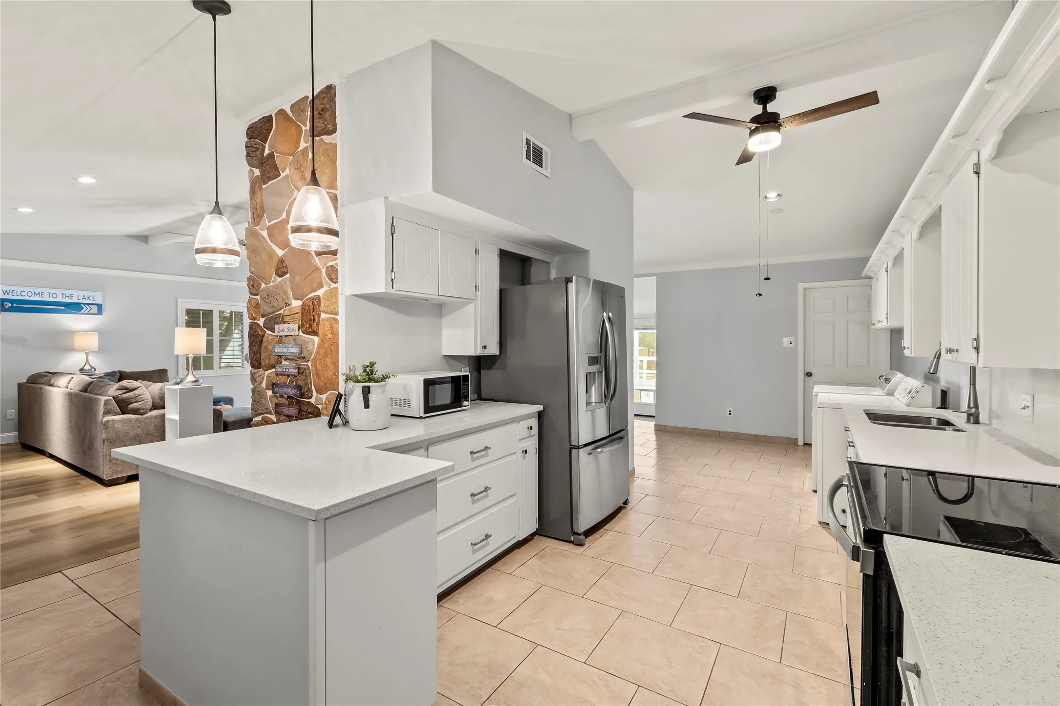 Kitchen featuring white cabinetry, light-toned countertops, stainless steel appliances, and tile flooring