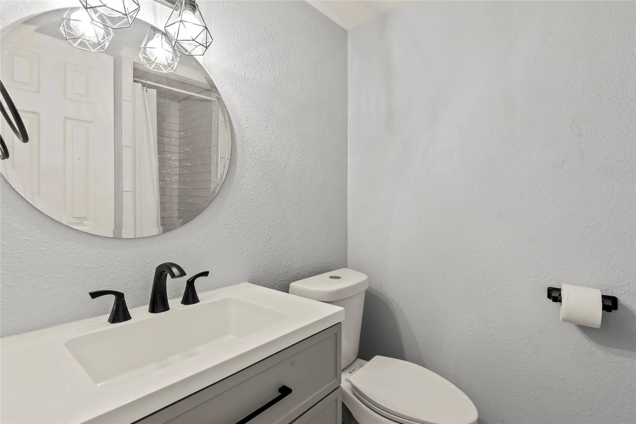 Modern vanity with an integrated sink, matte black faucet, and gray cabinetry