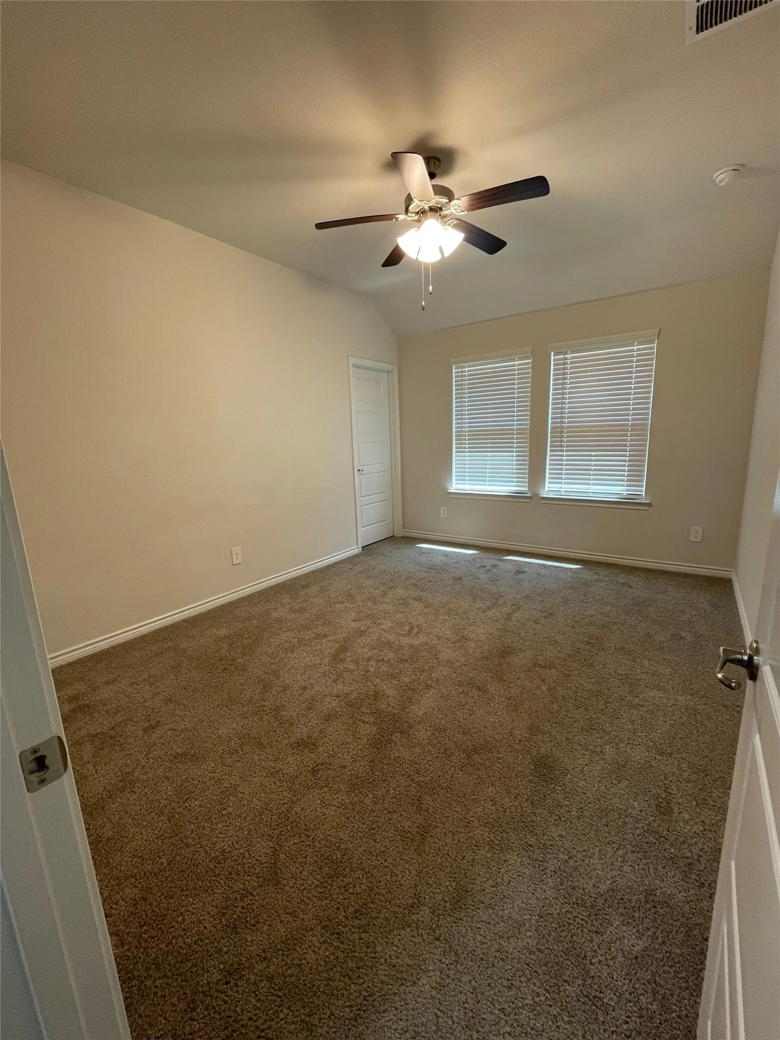 Spare room with carpet floors, ceiling fan, and lofted ceiling