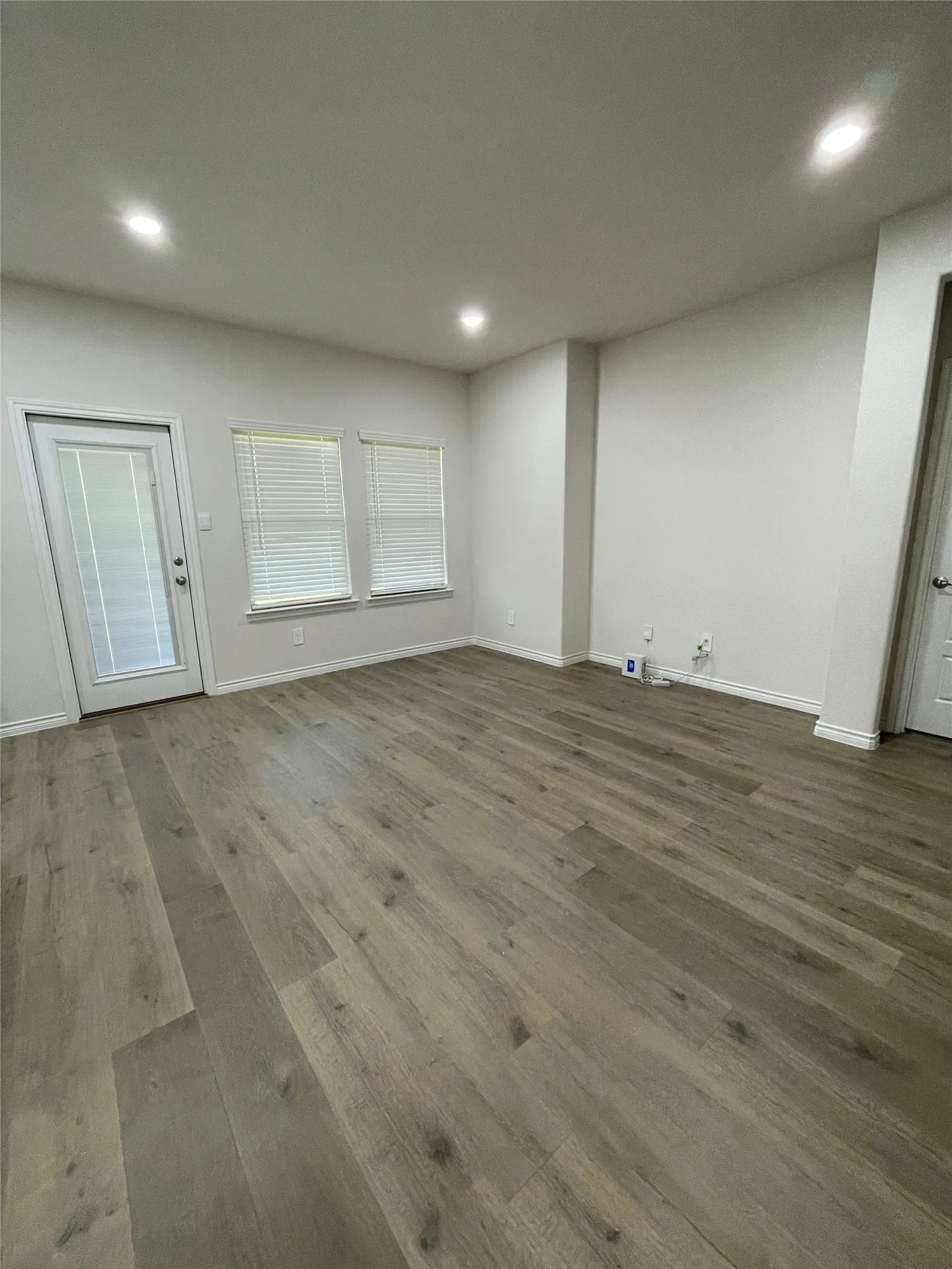 Unfurnished living room featuring wood finished floors and recessed lighting