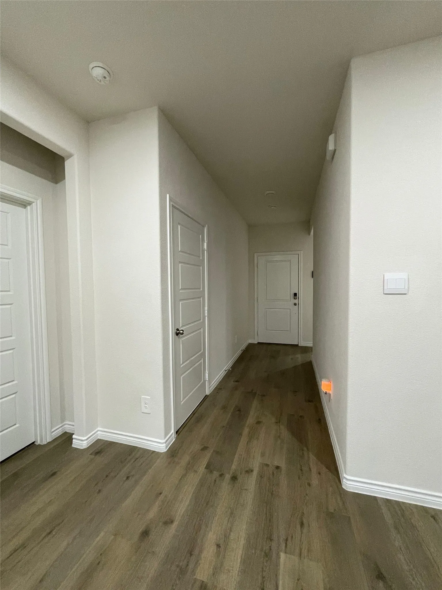Corridor with wood finished floors and baseboards