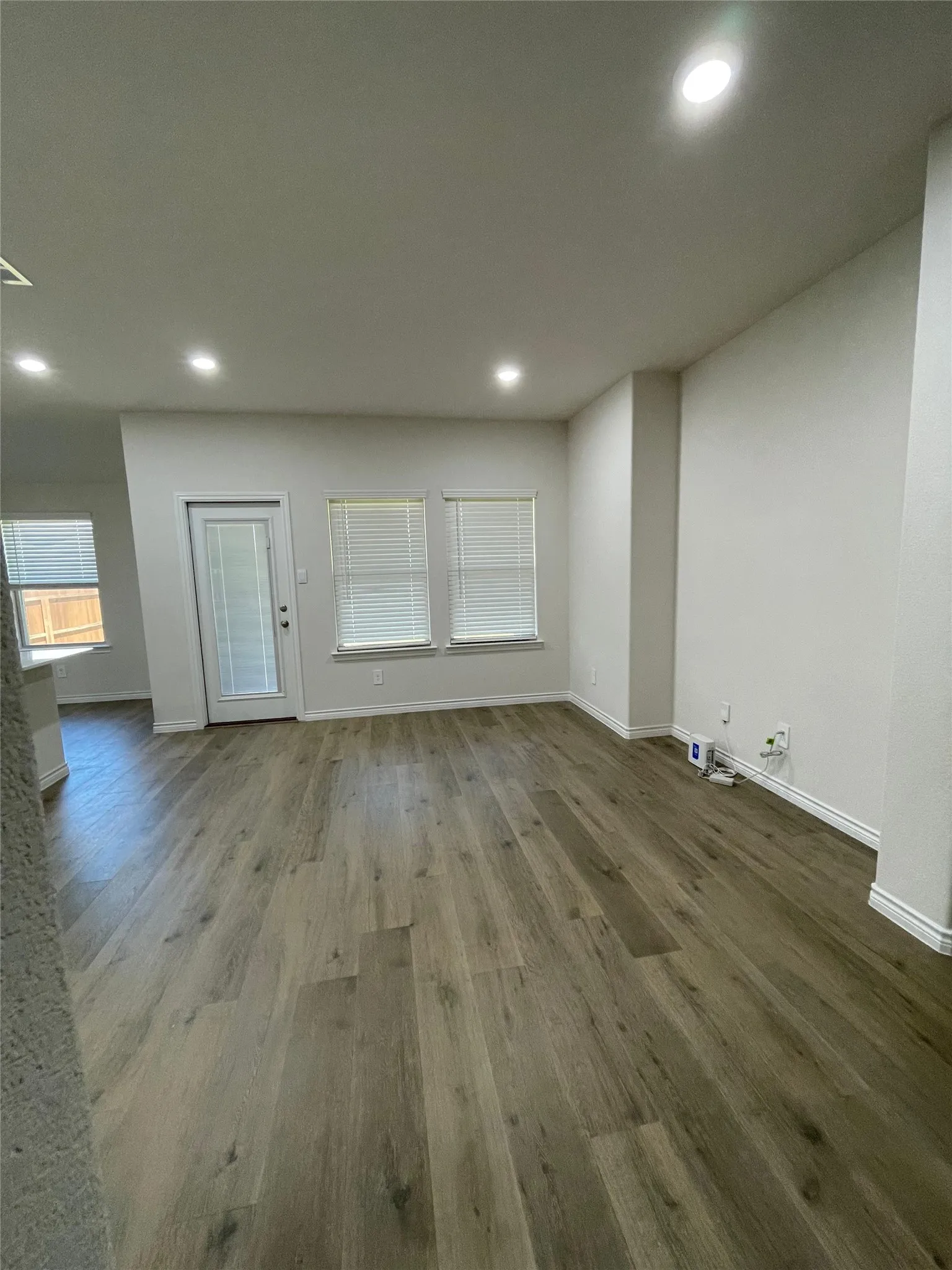 Unfurnished living room with wood finished floors and recessed lighting