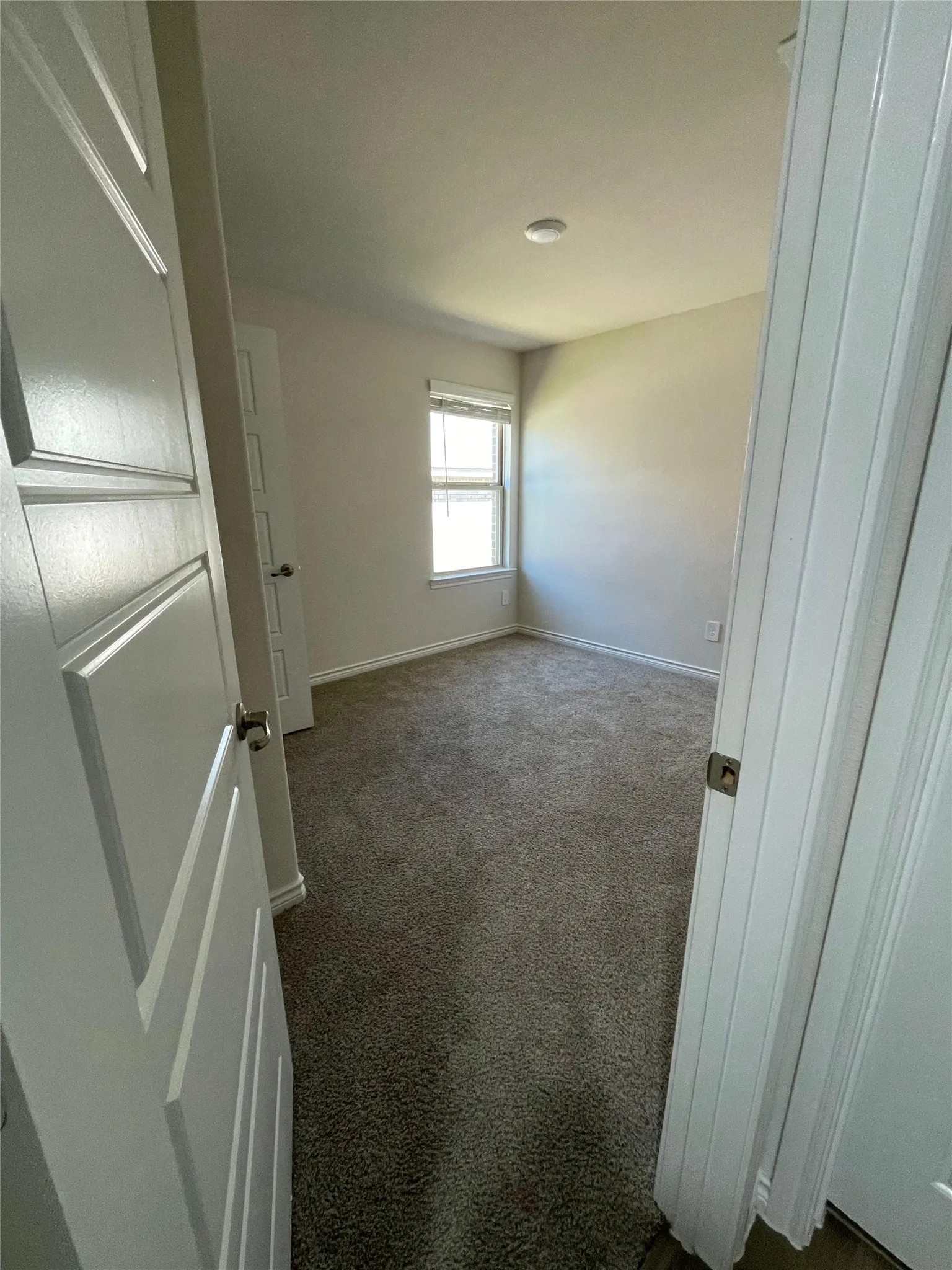 Empty room with dark carpet and baseboards