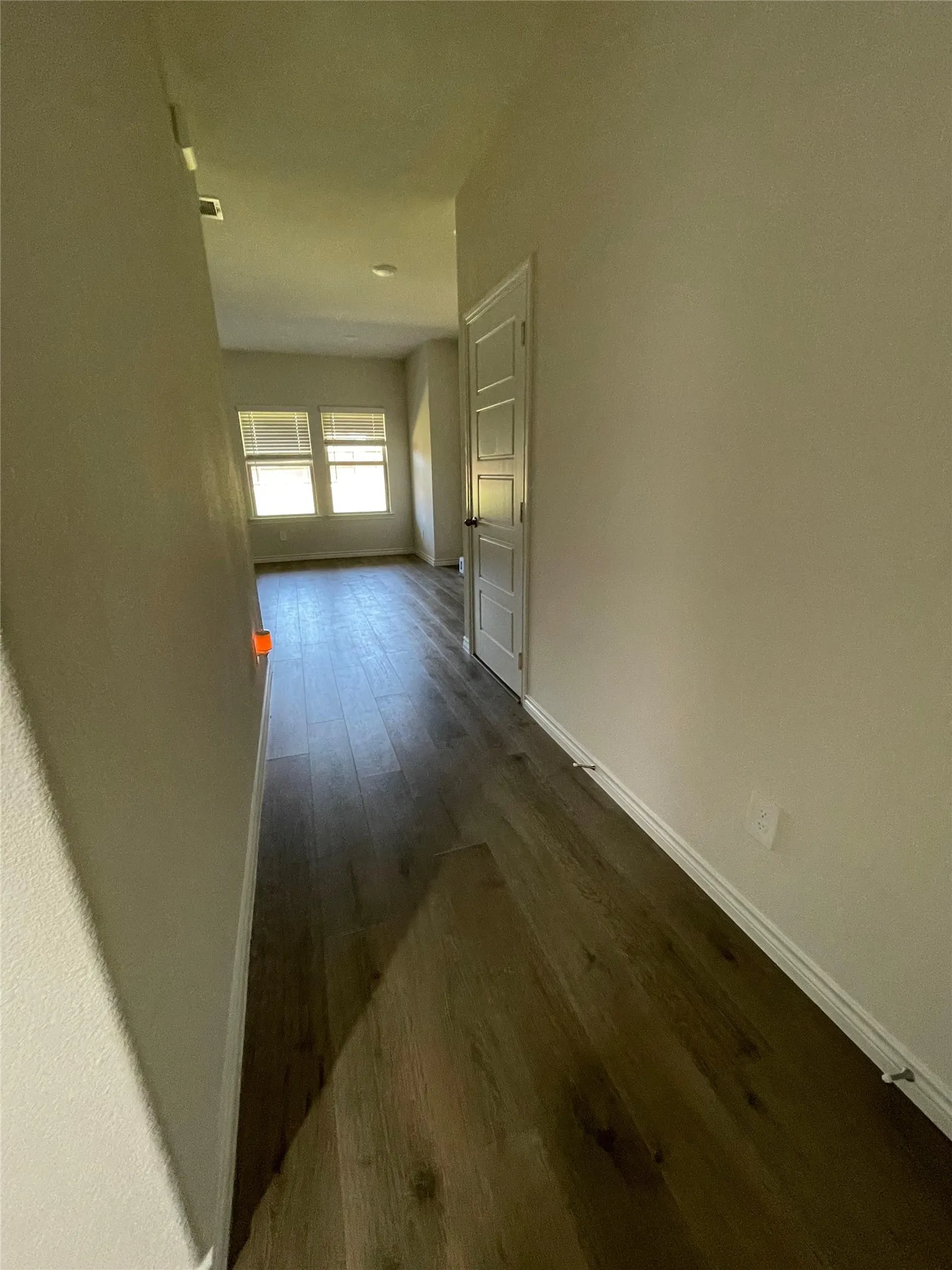 Hallway featuring dark wood-type flooring and baseboards