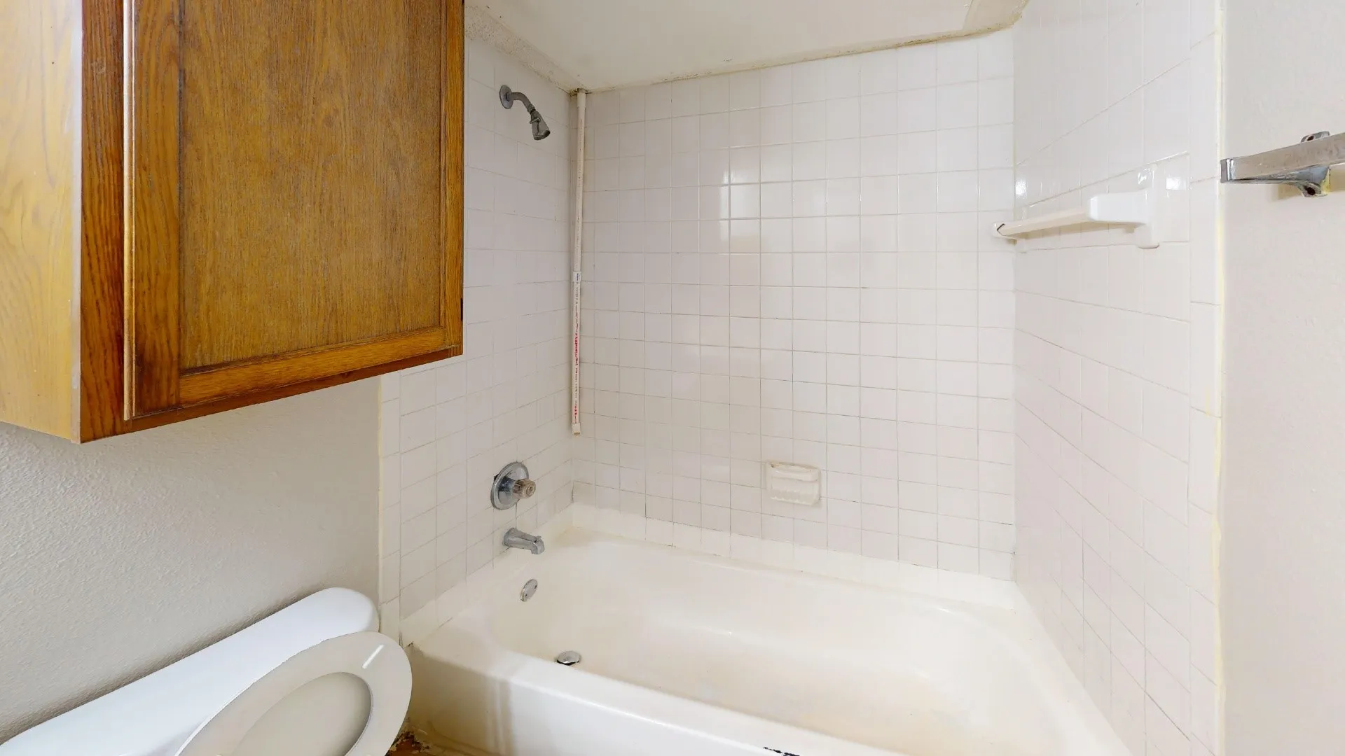White tiled shower surround with a built-in soap dish