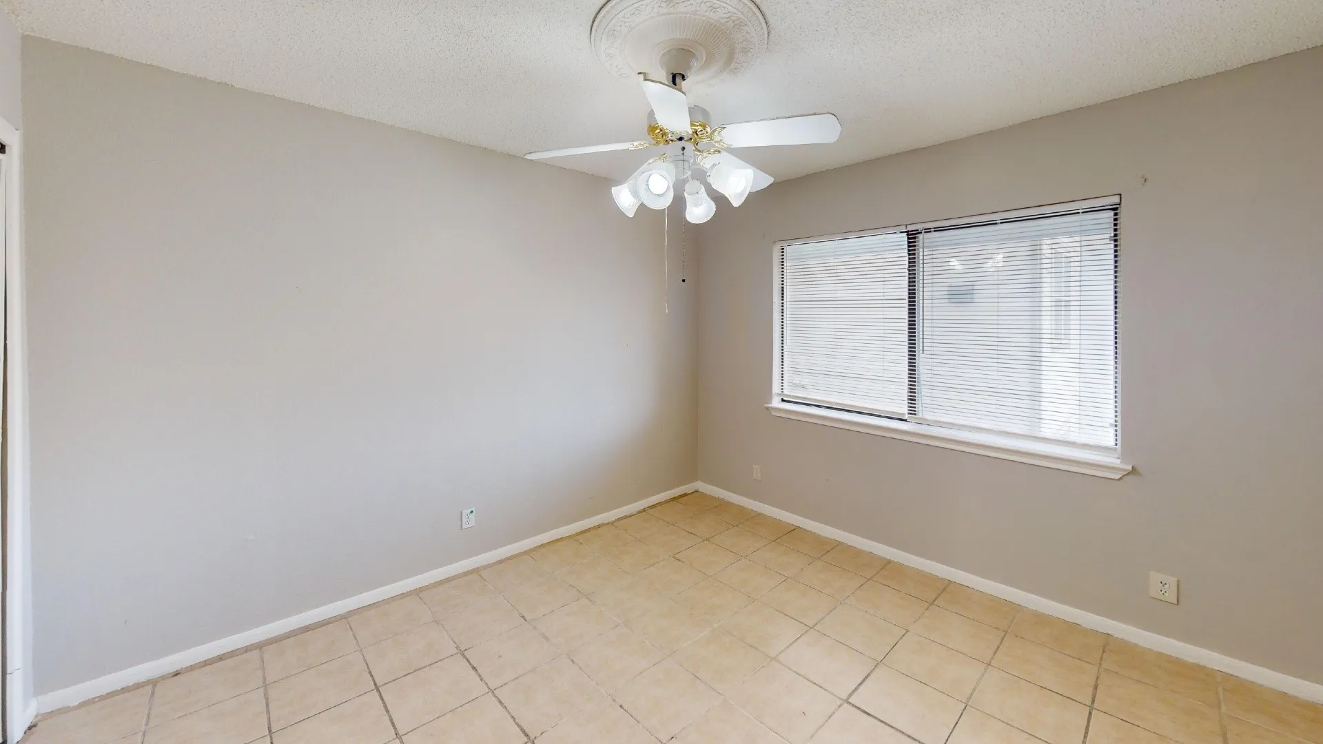 Tile flooring, neutral wall tones, window with horizontal blinds, and a ceiling fan with integrated lighting