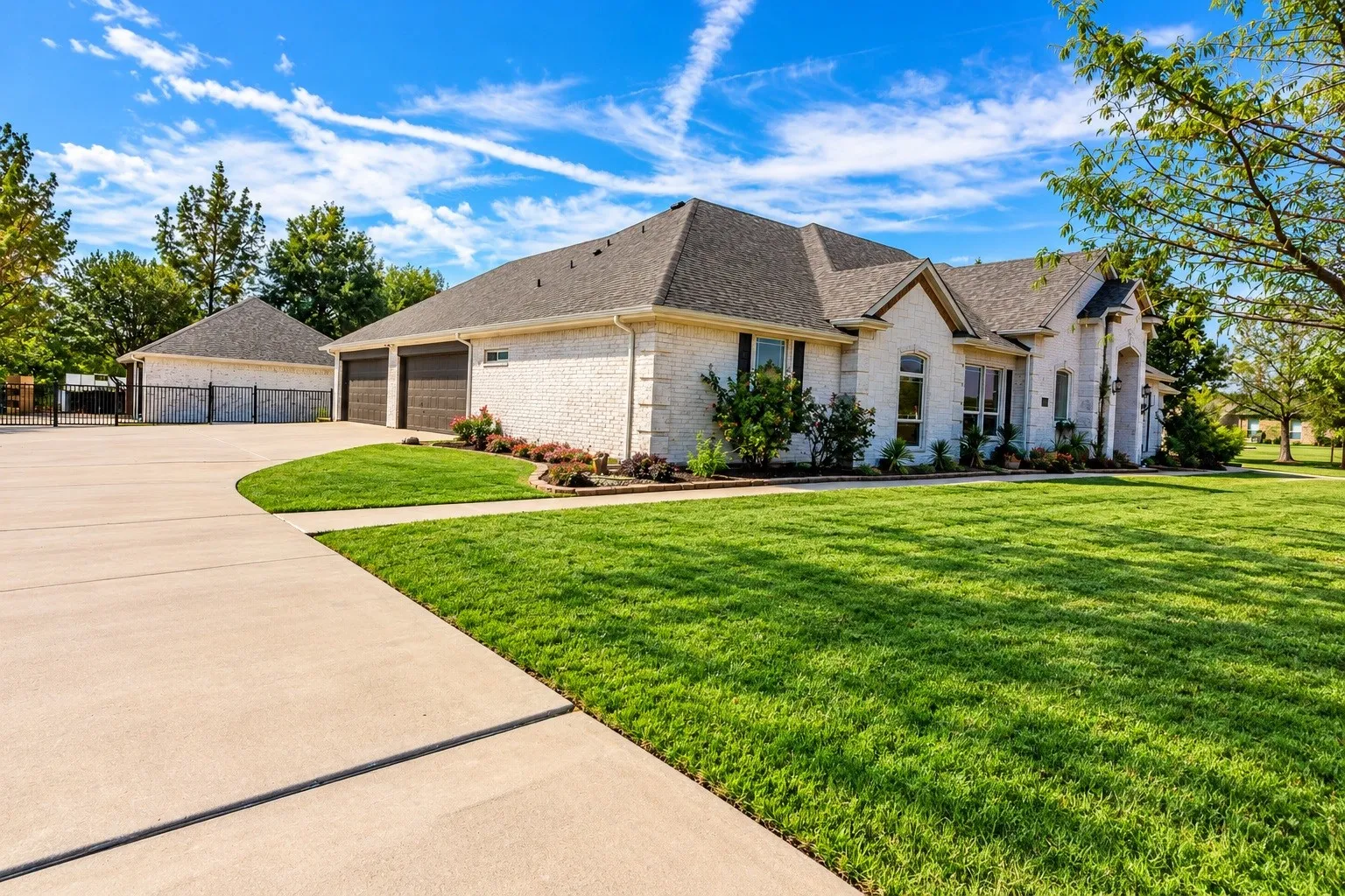 View of the side of the property showing attached 4 car garage.  Green grass has been virtually enhanced.