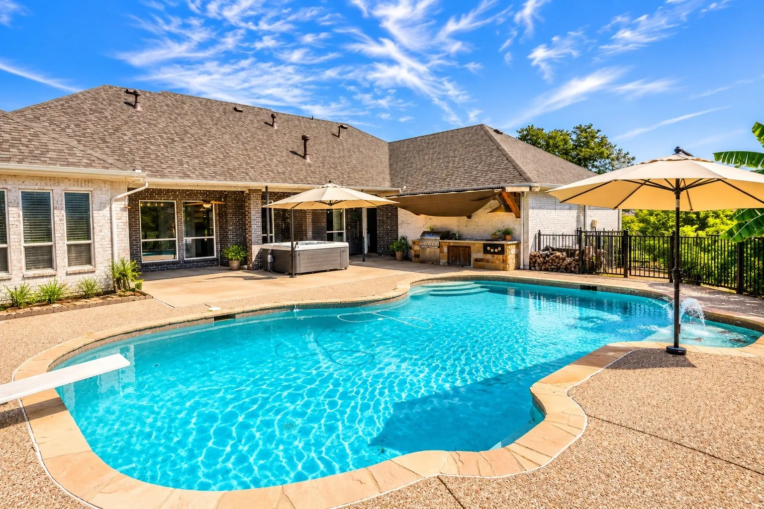View of pool area showing hot tub and outdoor kitchen