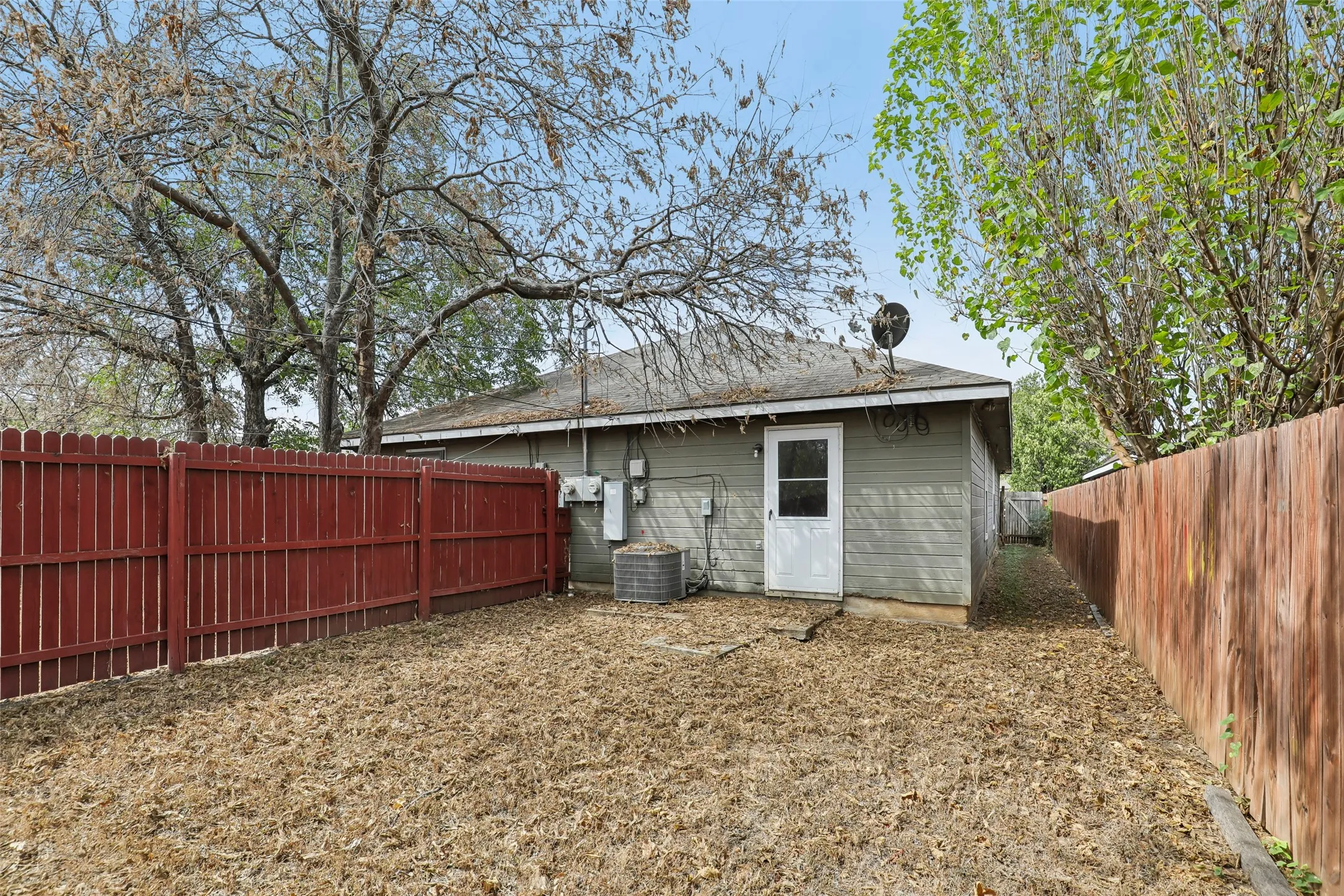 Unit 101 large backyard with grass and wood fence