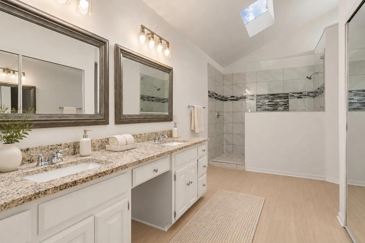 Primary bath with double vanity and walk-in shower. Virtually staged.