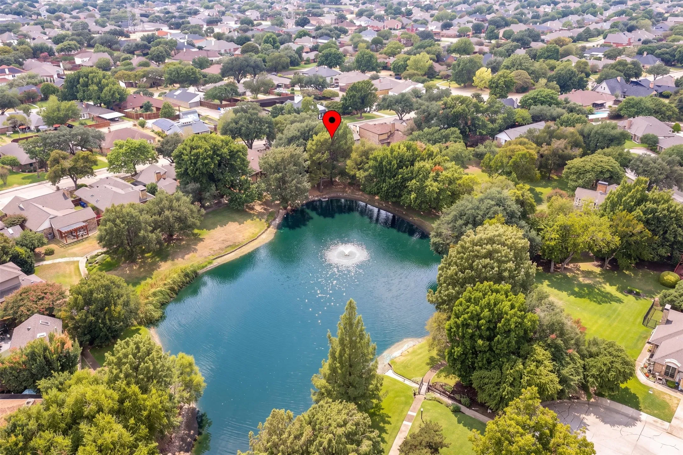 Aerial view showing the home and the neighborhood pond.