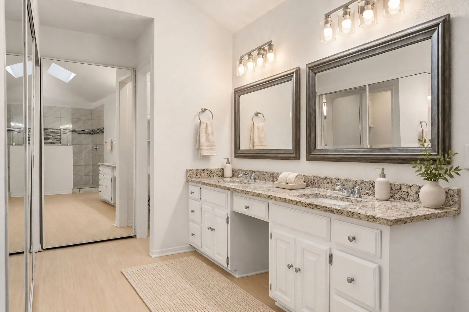Primary bath with mirrored closet doors. Virtually staged.